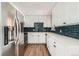 New eat-in kitchen with white cabinets, stainless appliances and modern backsplash at 15350 E Arizona Ave # 308, Aurora, CO 80017
