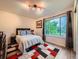 Inviting bedroom featuring a comfortable bed, decorative rug, and large window with scenic views at 12610 E Villanova Dr, Aurora, CO 80014