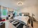 Bright bedroom featuring a large window, chandelier, and exercise equipment for a healthy lifestyle at 12610 E Villanova Dr, Aurora, CO 80014