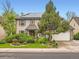 Attractive two-story brick home featuring a manicured lawn, mature trees, and a driveway leading to an attached garage at 12610 E Villanova Dr, Aurora, CO 80014
