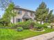 Charming two-story brick home with blue shutters and a lush, well-maintained front yard with mature trees at 12610 E Villanova Dr, Aurora, CO 80014