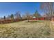 Expansive grassy backyard with an orange wooden fence, offering privacy and an open space for activities at 12771 Clermont St, Thornton, CO 80241