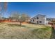 Large, grassy backyard featuring a young tree and an orange wooden fence for privacy and outdoor enjoyment at 12771 Clermont St, Thornton, CO 80241