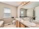 Bathroom with double vanity, large mirror, tiled floors, and soaking tub with shower at 12771 Clermont St, Thornton, CO 80241