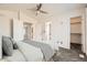 Bright, carpeted bedroom featuring neutral paint, a ceiling fan, and adjoining bathroom and closet at 12771 Clermont St, Thornton, CO 80241