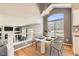 Elegant dining area with a modern chandelier, large window, and a view of the adjacent living room at 12771 Clermont St, Thornton, CO 80241