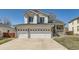 Attractive two-story home with a three-car garage, stone accents, well-manicured lawn, and inviting front porch at 12771 Clermont St, Thornton, CO 80241
