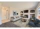 Bright living room featuring a fireplace, built-in shelving, neutral color palette, and comfortable seating at 12771 Clermont St, Thornton, CO 80241
