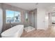 Bright bathroom showcases a modern freestanding tub, glass shower, and large window, perfect for relaxation at 13753 Jasmine St, Thornton, CO 80602