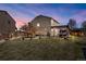 Picturesque backyard at twilight, featuring a pergola, lush lawn, and soft string lights on a tree at 10732 Cook Ct, Northglenn, CO 80233