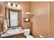 Cozy half bathroom featuring a framed mirror, decorative shelf, and floral arrangement at 10732 Cook Ct, Northglenn, CO 80233