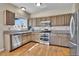 Well-appointed kitchen with wood cabinets, stainless steel appliances, granite countertops and hardwood floors at 10732 Cook Ct, Northglenn, CO 80233