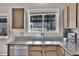 Bright kitchen sink with granite countertops, modern faucet, mosaic backsplash, and view of the patio at 10732 Cook Ct, Northglenn, CO 80233