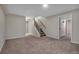 Finished basement with neutral carpet, staircase, and doorway offering flexible living space at 5149 S Tibet St, Aurora, CO 80015