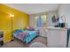 Bright bedroom features yellow accent wall, plush carpet, and a modern window with yellow curtains at 5149 S Tibet St, Aurora, CO 80015