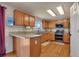The bright kitchen has wood cabinets, stainless appliances and granite countertops at 5149 S Tibet St, Aurora, CO 80015