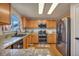 Well-lit kitchen features granite counters, wood cabinets, stainless steel appliances, and double oven at 5149 S Tibet St, Aurora, CO 80015