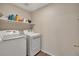 Spacious laundry room includes modern washer and dryer with a storage shelf at 5149 S Tibet St, Aurora, CO 80015