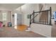 View of the living room featuring beautiful hardwood floors, stairs with dark railings, and large windows at 5149 S Tibet St, Aurora, CO 80015