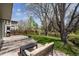 Spacious backyard with a stone patio, lush lawn, mature trees, and an inviting outdoor seating area at 7942 S Vincennes Way, Centennial, CO 80112