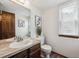 Bright bathroom featuring a single sink vanity with a marble countertop and a decorative mirror at 7942 S Vincennes Way, Centennial, CO 80112