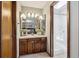 Well-lit bathroom with a triple mirror above the vanity and a glass-enclosed shower at 7942 S Vincennes Way, Centennial, CO 80112