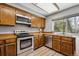 Well-lit kitchen features stainless steel appliances and warm wooden cabinets and countertops at 7942 S Vincennes Way, Centennial, CO 80112