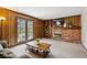 Cozy living room with wood paneling, a brick fireplace, and French doors leading to the backyard at 7942 S Vincennes Way, Centennial, CO 80112
