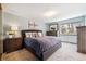 Serene main bedroom featuring a tufted headboard, soft lighting, and a dresser with a mirror at 7942 S Vincennes Way, Centennial, CO 80112