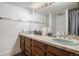 Bright bathroom vanity offers dual sinks, wood cabinetry, and an oversized mirror at 3312 S Ouray Way, Aurora, CO 80013