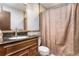 Bathroom featuring a granite countertop, wood vanity, large mirror and a shower with a curtain at 3312 S Ouray Way, Aurora, CO 80013