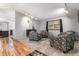 Bright living room features hardwood floors, neutral paint, modern lighting, and comfortable armchairs at 3312 S Ouray Way, Aurora, CO 80013