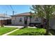 Back exterior featuring a green lawn, a patio area, and a tidy facade at 3155 N Steele St, Denver, CO 80205