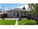 Back exterior showcasing a backyard with a patio area, grassy lawn, and charming landscaping at 3155 N Steele St, Denver, CO 80205