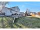 View of the backyard with a stone terraced patio with seating, a trampoline and grassy lawn at 5431 E 129Th Ave, Thornton, CO 80241