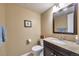 Cozy powder room featuring a granite countertop, dark wood vanity, and neutral paint at 5431 E 129Th Ave, Thornton, CO 80241