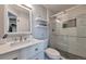 Modern bathroom featuring white vanity, floating shelves, and glass-enclosed shower with gray and white marble tile at 5431 E 129Th Ave, Thornton, CO 80241