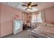 Charming pink bedroom with a ceiling fan, white dresser, and a cozy bed; decorated with hanging vines at 5431 E 129Th Ave, Thornton, CO 80241