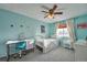 Bright bedroom with turquoise walls, ceiling fan, and a desk; the room has a cozy and inviting atmosphere at 5431 E 129Th Ave, Thornton, CO 80241