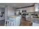 Modern kitchen with white cabinets, stainless steel appliances, island with bar seating and hardwood floors at 5431 E 129Th Ave, Thornton, CO 80241