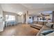 Open-concept living room with wood floors, a large sectional, and an adjacent kitchen provides ample space at 5431 E 129Th Ave, Thornton, CO 80241