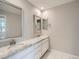 Modern bathroom featuring dual sinks with granite counters, framed mirrors, and tile flooring at 10371 Harrisburg St, Parker, CO 80134