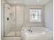 Elegant bathroom featuring a glass enclosed shower, a tub, and window offering ample natural light at 10371 Harrisburg St, Parker, CO 80134