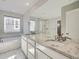 Bright bathroom featuring dual sinks with granite counters, a soaking tub, and a glass-enclosed shower at 10371 Harrisburg St, Parker, CO 80134