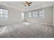 Spacious bedroom with neutral carpet, tray ceiling, fan, and multiple windows providing abundant natural light at 10371 Harrisburg St, Parker, CO 80134
