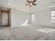 Spacious main bedroom with neutral carpet, ceiling fan, and natural light from two windows at 10371 Harrisburg St, Parker, CO 80134