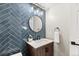 Stylish powder room with blue herringbone tile, round mirror, and a modern vanity at 7476 E Arkansas Ave # 35-01, Denver, CO 80231
