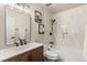 Modern bathroom with wood vanity, white tile, shower and tub combination at 7476 E Arkansas Ave # 35-01, Denver, CO 80231