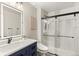 Contemporary bathroom with an updated vanity, stylish lighting, and glass shower enclosure with a sleek black sliding door at 7476 E Arkansas Ave # 35-01, Denver, CO 80231