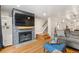 Comfortable living room with stone fireplace, tv, hardwood floors, and stairway at 7476 E Arkansas Ave # 35-01, Denver, CO 80231